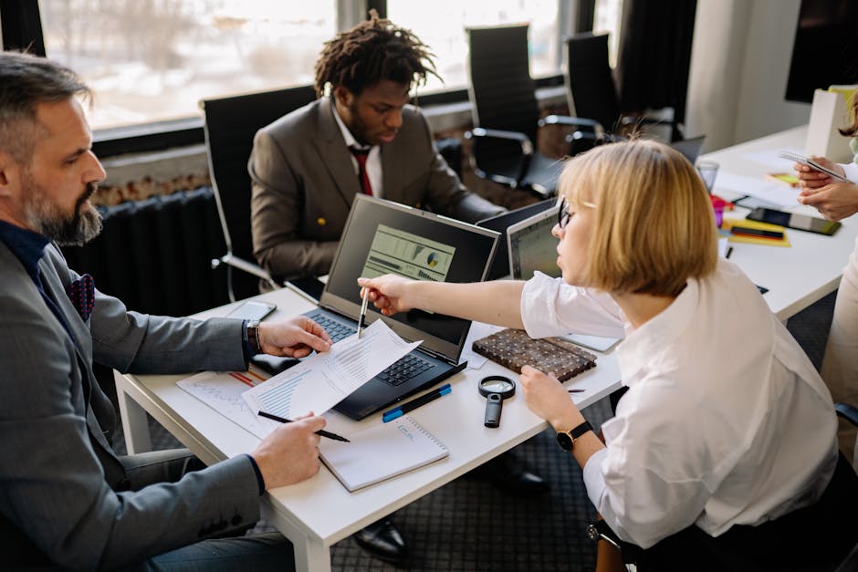 Business team of three discussing project plans in a modern office setting