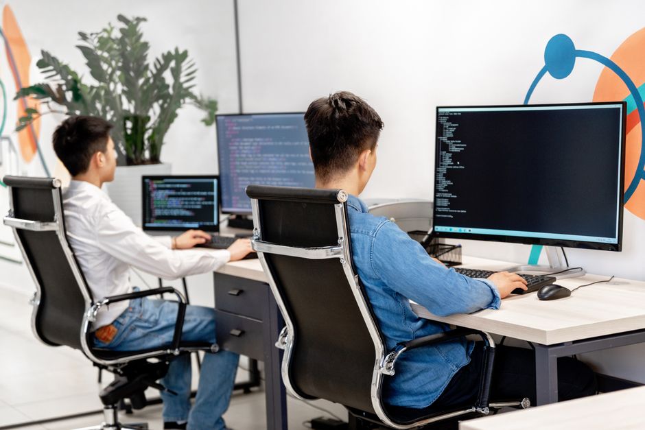Dva developera programiraju na velikim monitorima